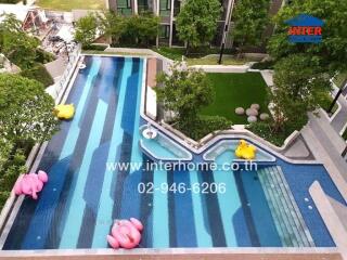 Swimming pool with surrounding greenery and buildings