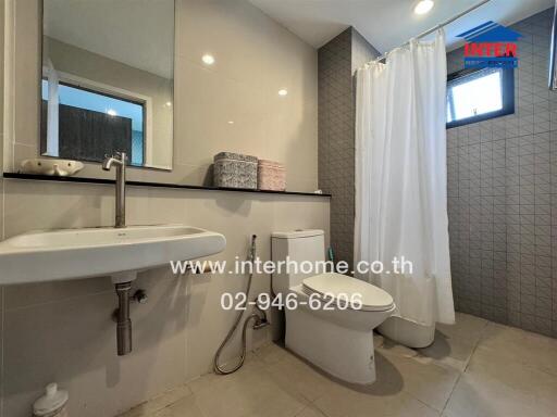 Modern bathroom with sink, toilet, and shower