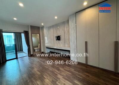 Spacious living room with wooden floor, built-in cabinets, and access to a balcony.