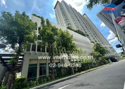 Exterior view of a tall residential building with trees and a clear sky