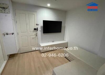 Modern living room with TV, wooden floor, and white couch