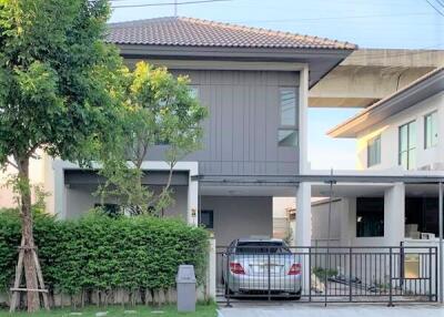 Front view of a modern two-story house with a car parked in the driveway