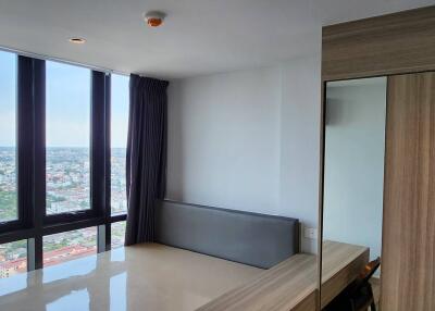 Bedroom with large windows and city view