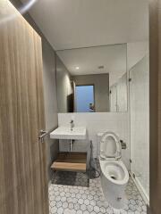 Modern bathroom with a large mirror, sink, and toilet