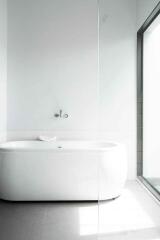 Modern minimalistic bathroom with bathtub and large window