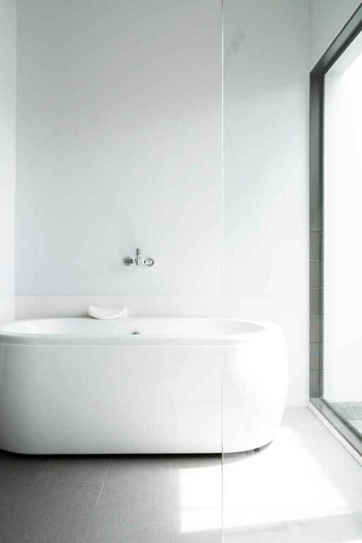 Modern minimalistic bathroom with bathtub and large window