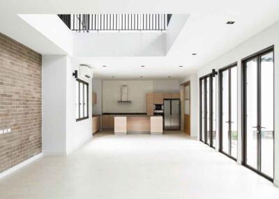 Spacious modern living area with a view into the kitchen and large windows