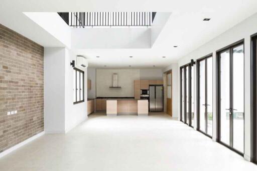 Spacious modern living area with a view into the kitchen and large windows