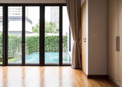 Living room view with large windows overlooking pool area