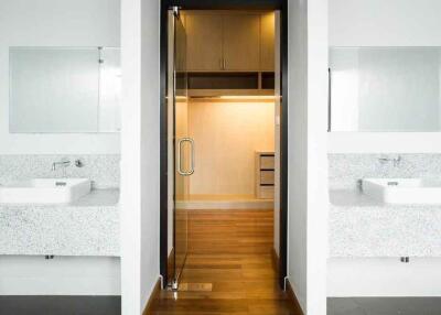 Modern bathroom with dual sinks and walk-in closet