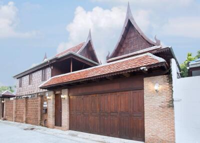 Traditional Thai style house with wooden elements and decorative roof designs