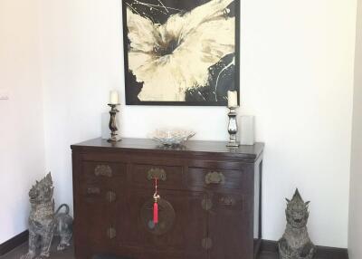 Elegantly decorated living area with wooden cabinet and artistic decor