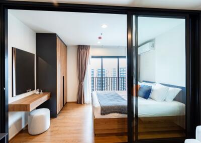 Modern bedroom with wooden flooring and balcony view