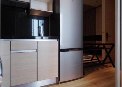 Modern kitchen with stainless steel refrigerator, wooden cabinets, and built-in appliances