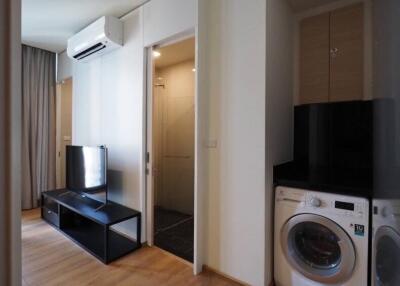 Living area with television, air conditioner, and laundry machine