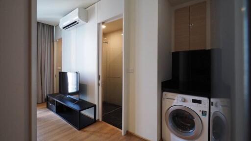 Living area with television, air conditioner, and laundry machine