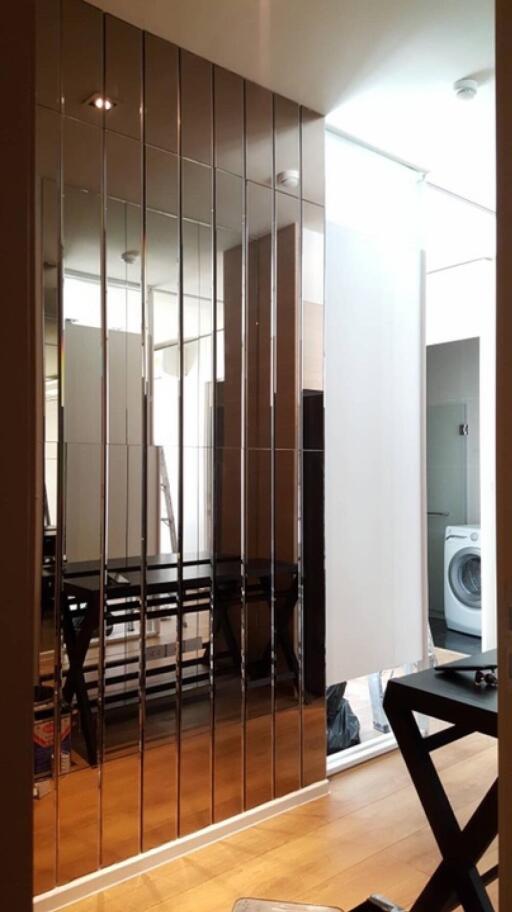 Laundry room with washing machine and mirror panel wall