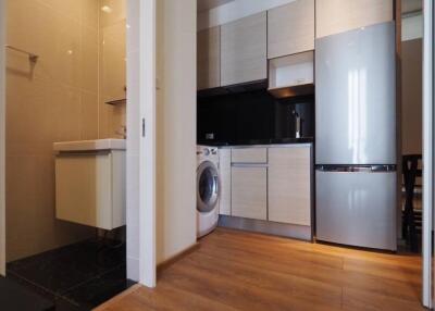 Modern kitchen with adjacent laundry area and sleek appliances