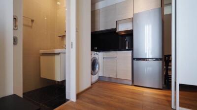 Modern kitchen with adjacent laundry area and sleek appliances