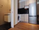 Modern kitchen with adjacent laundry area and sleek appliances