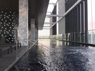 modern indoor swimming pool area with marble and tile decor