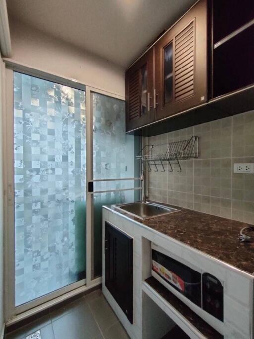 Modern compact kitchen with dark wood cabinets and frosted sliding glass door