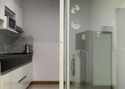 Modern kitchen with built-in appliances and adjacent laundry area