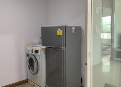 Laundry area with washing machine and refrigerator