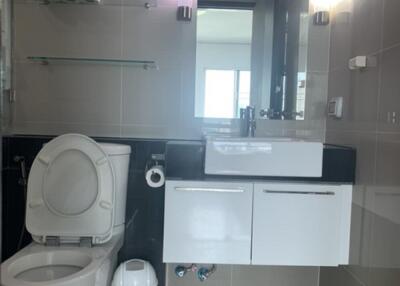 Modern bathroom with toilet, sink, and shelves