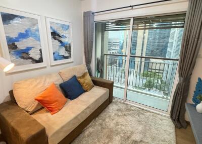 Living room with couch, artwork, and balcony access