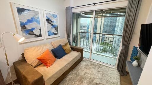 Living room with couch, artwork, and balcony access