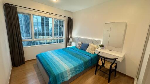 Modern bedroom with large window and simple furnishings