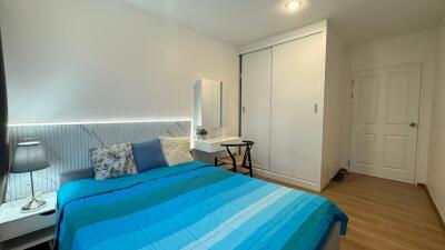 Modern bedroom with blue bedding and a closet