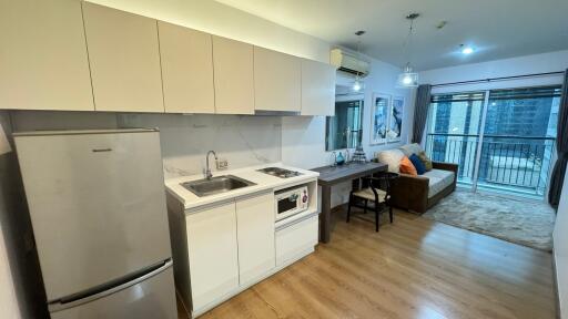 Modern living area with kitchenette and balcony