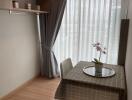 Cozy dining area with table and chairs next to a large window