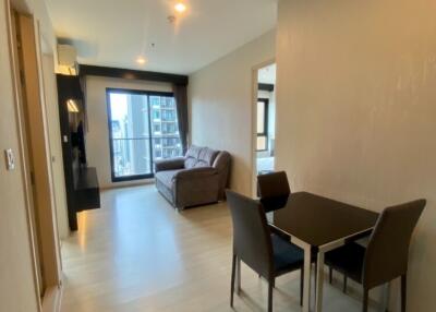 Modern living room with dining area, sofa, and wall-mounted TV