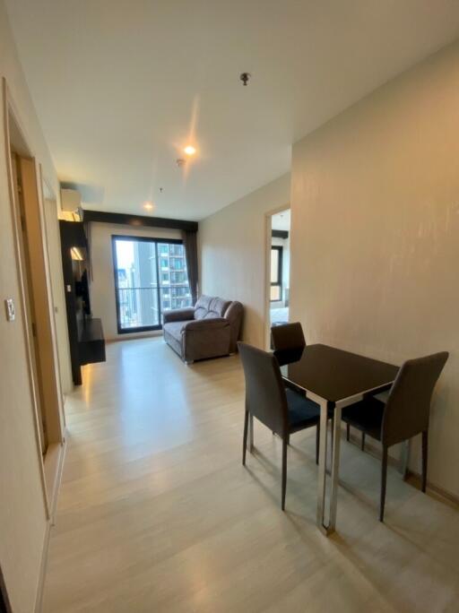 Modern living room with dining area, sofa, and wall-mounted TV