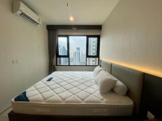 Modern bedroom with a large window and city view