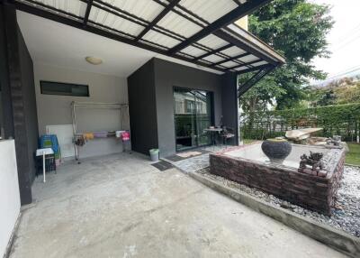 Covered outdoor area with laundry equipment and decorative fountain