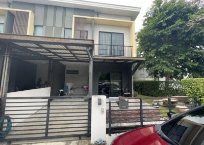 Front view of a two-story modern house with a carport