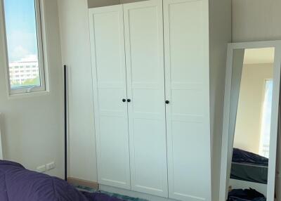 Bedroom with white wardrobe, full-length mirror, and purple bedding