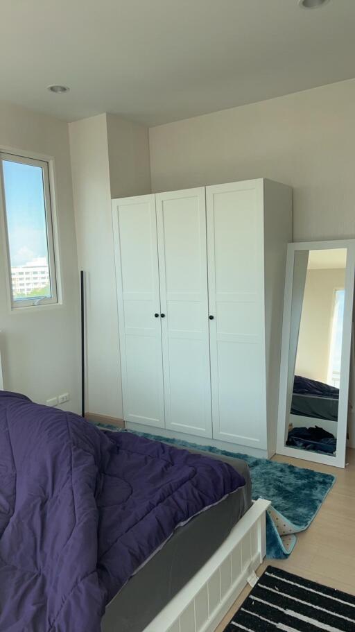 Bedroom with white wardrobe, full-length mirror, and purple bedding