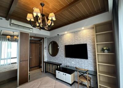 Bedroom with modern decor featuring a TV, chandelier, and wooden ceiling