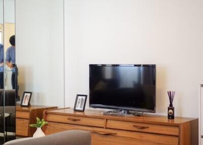 Living room with wooden TV cabinet and wall-mounted television