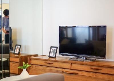 Modern living room with a TV and wooden cabinets