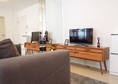 Living room with a couch, TV, and wooden console