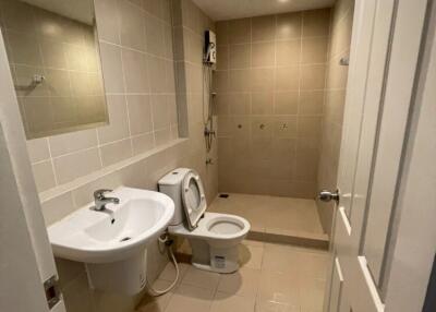 Bathroom with toilet, sink, and shower area