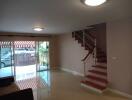 spacious living room with a view of the patio and stairs leading to the upper floor