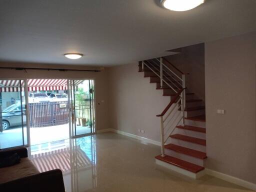 spacious living room with a view of the patio and stairs leading to the upper floor