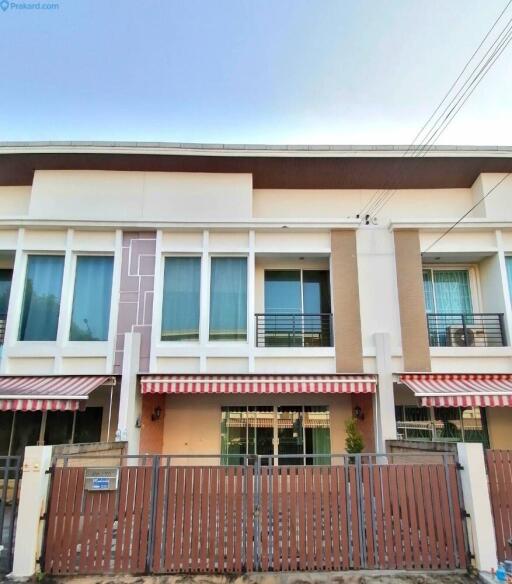 Front facade of a multi-story townhouse with a gated entrance.